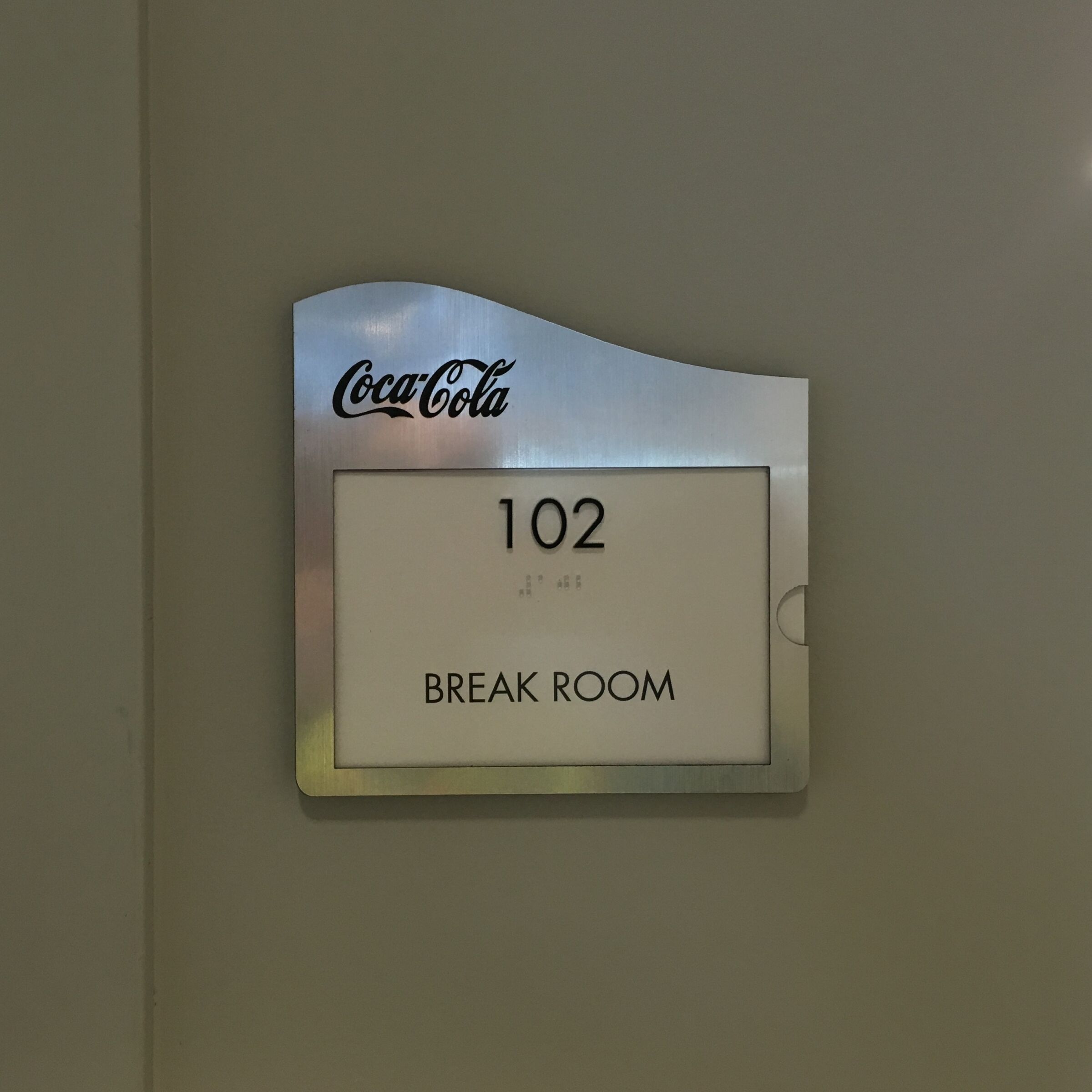 Room number sign for offices with Braille under the number.