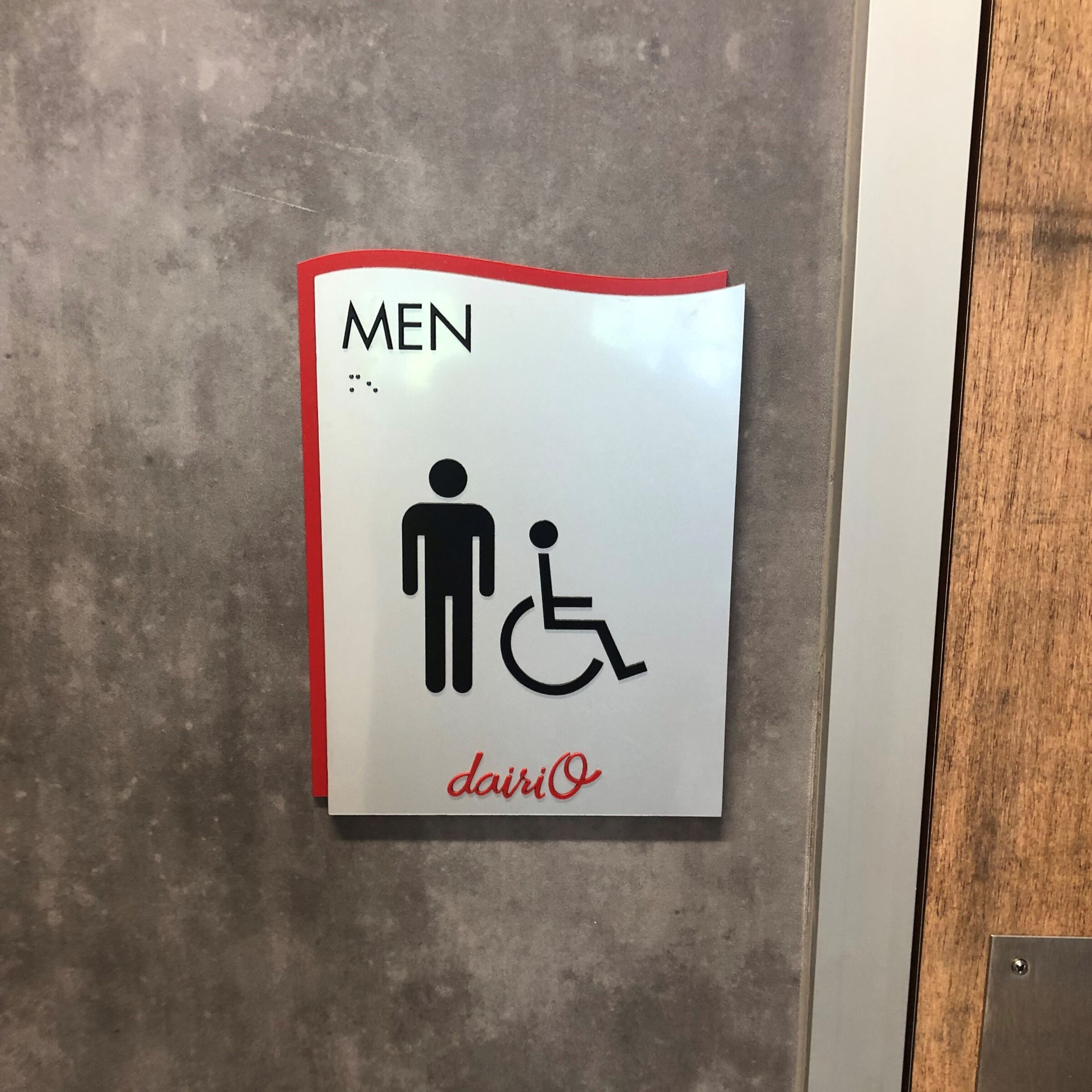 Men bathroom sign with braille under written text.